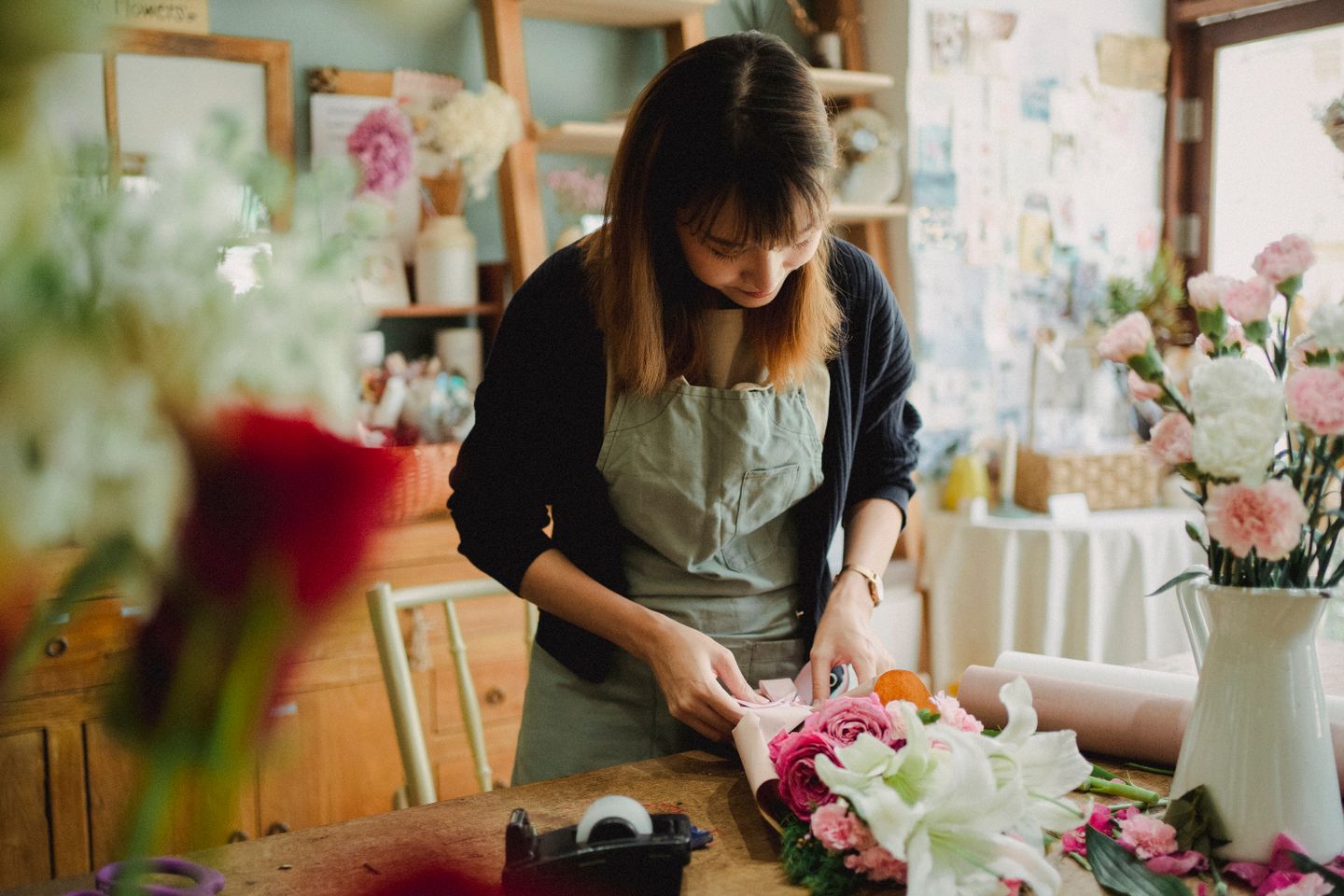Fleuriste préparant un bouquet dans sa boutique — commandes gérées par SpotUp CRM